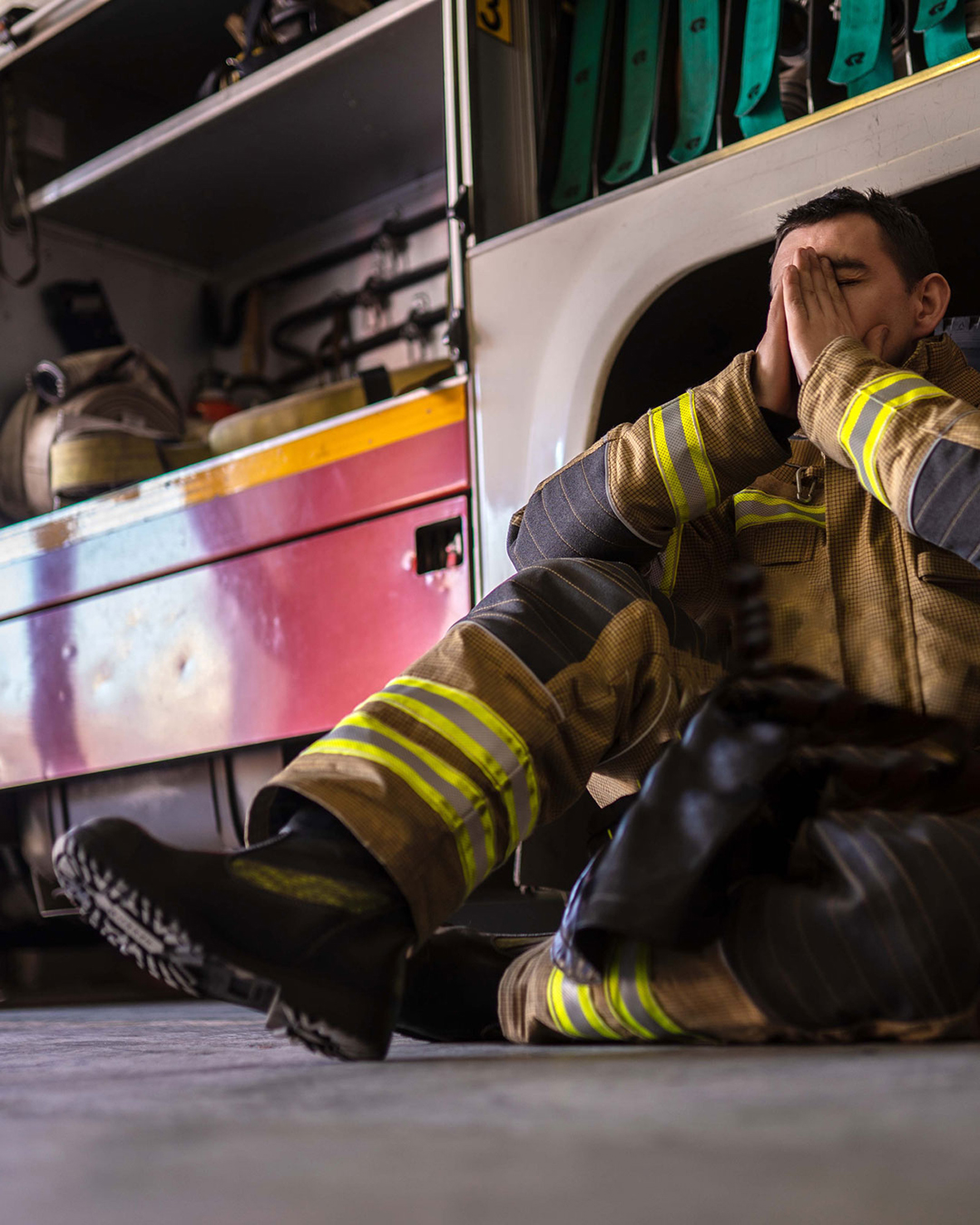 Firefighter sitting next to fire engine